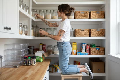 girl with tattoos brown hair white shirt jeans checkerd shoes cleaning out organizing panrtry